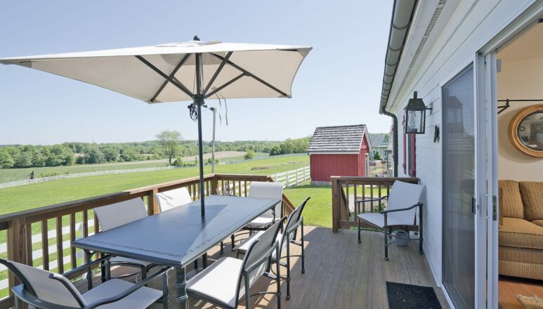deck with umbrella overlooking land off of Carriage House
