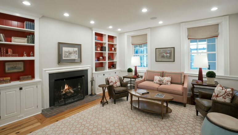 living room with blazing fireplace and bookshelves