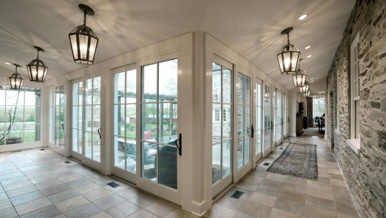 hallway of windows and glass doors against stone wall